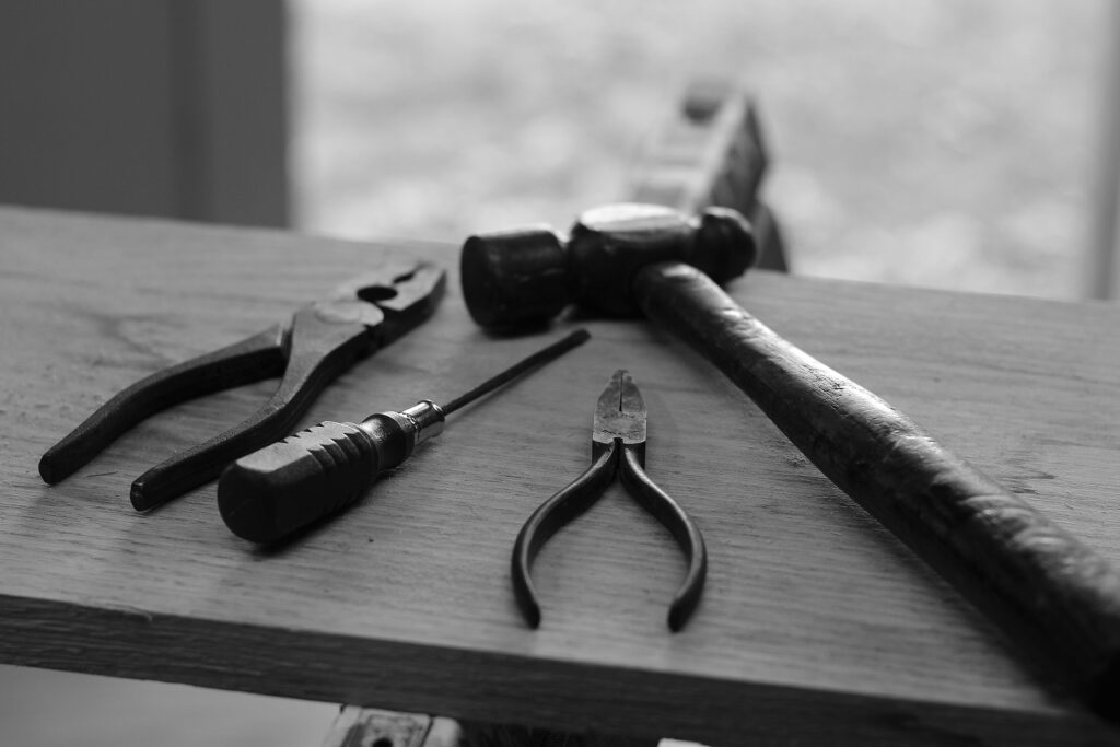 Various carpentry tools such as hammers, saws, and measuring instruments arranged on a workbench